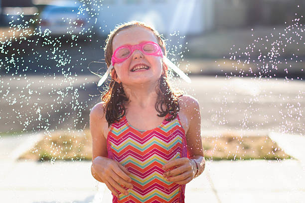istock Young girl plays in sprinkler 504241314