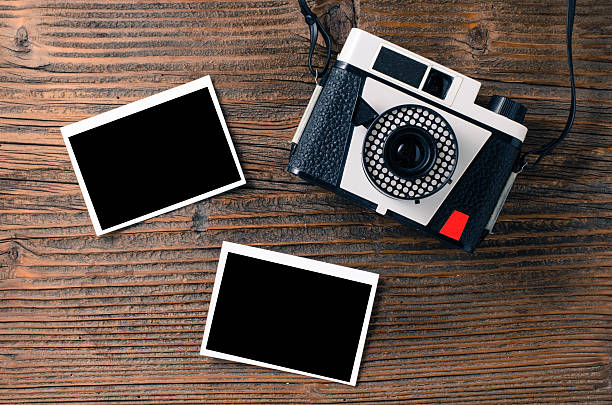 istock Vintage camera and old photos on wooden table 504241858