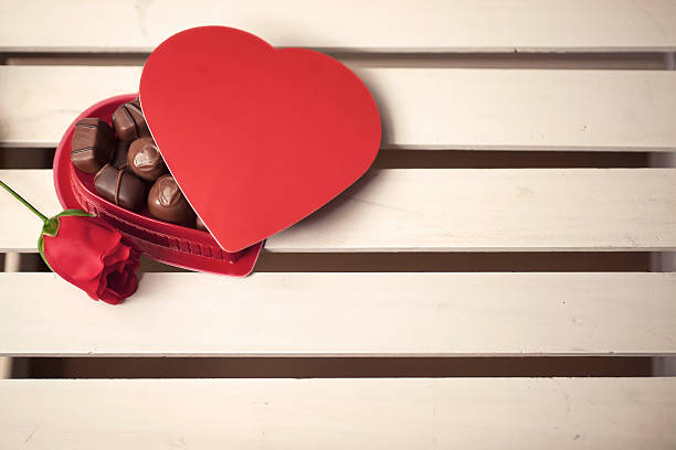 Coração em forma de caixa de Chocolates e uma rosa - foto de acervo
