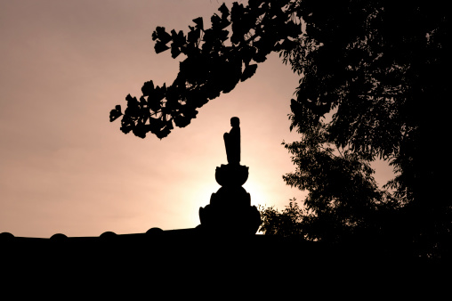silhouette of buddhist statue against a sunrise in Gimje, South Korea
