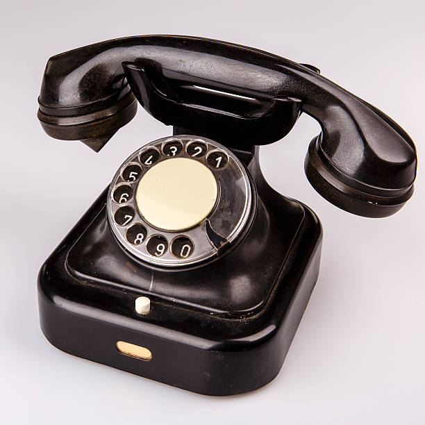 istock Old black phone with dust and scratches on white background 504243756