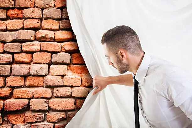 Photo of businessman pulls the curtain and discovers a brick wall
