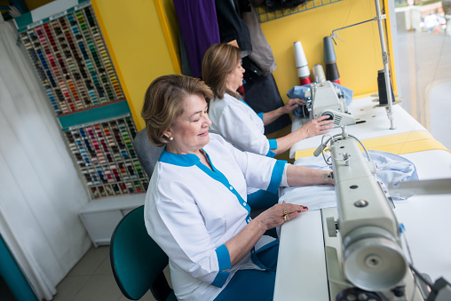 Latin American women sewing clothes using machines - small business concepts