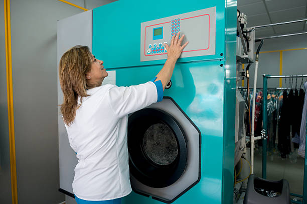 A vibrant laundromat featuring modern washing machines against a bright yellow wall. The organized space offers convenience for laundry chores in a clean environment.