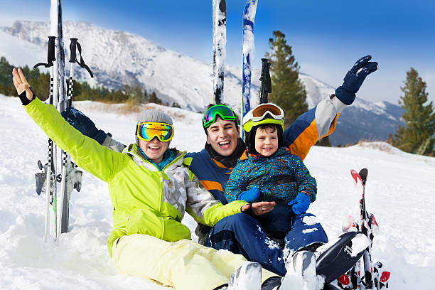 istock Happy family with hands up on snow after skiing 504244065