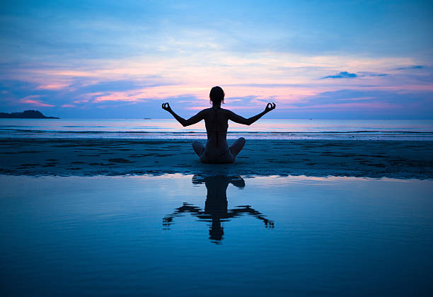 istock Woman practicing yoga on the beach at sunset 504244359