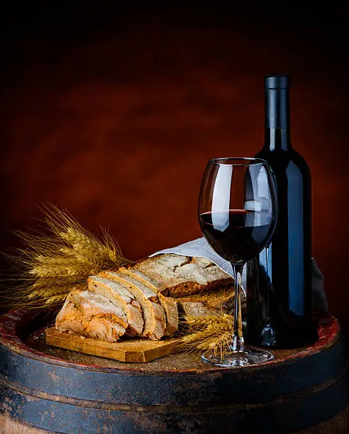 red wine, sliced bread and whteat in a rustic setup