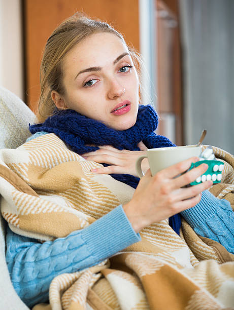 istock Young woman having cold under plaid at home 504245296