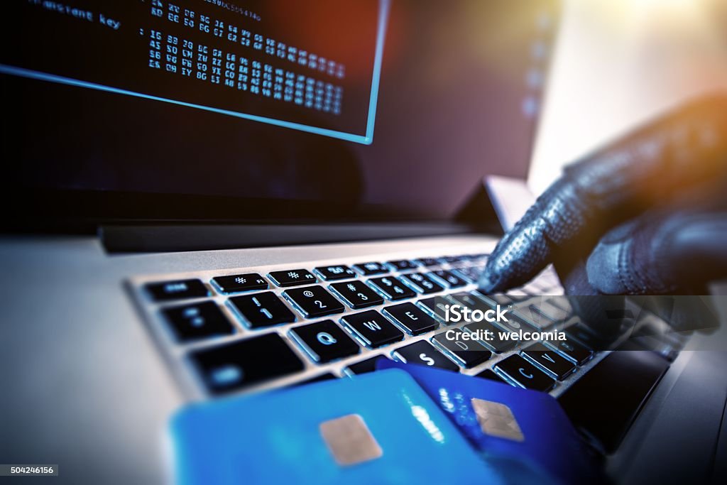Unauthorized Payments Credit Cards Theft Concept. Hacker with Credit Cards on His Laptop Using Them For Unauthorized Shopping. Unauthorized Payments Gangster Stock Photo
