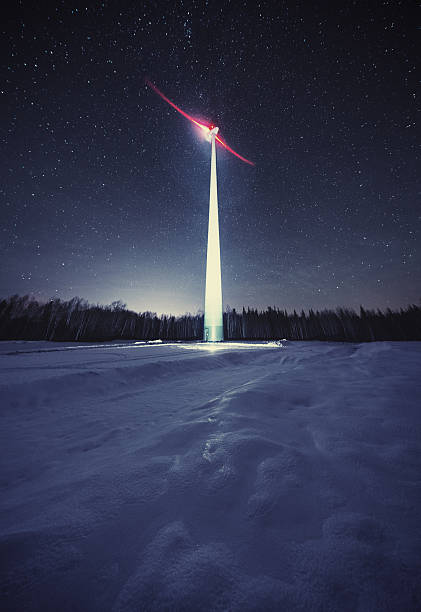 A windmill spins in near silence under a January night sky.  Long exposure.