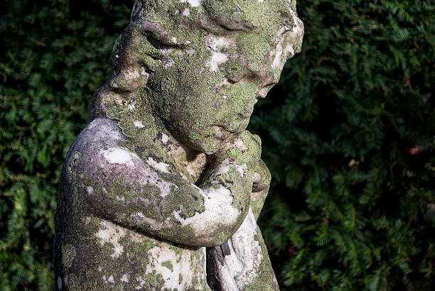 Statue of an angel child praying and looking at sky.