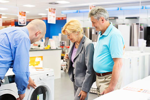 Senior couple buying a washing machine http://bit.ly/18e8x4d  electronics store stock pictures, royalty-free photos & images