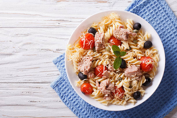 fusilli pasta with tuna, tomatoes and parmesan. horizontal top v fusilli pasta with tuna, tomatoes and parmesan on the table. horizontal top view fusilli stock pictures, royalty-free photos & images