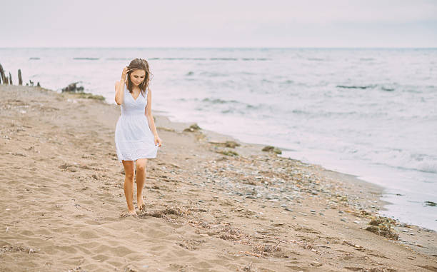 istock Beautiful young woman walking on beach 504279266