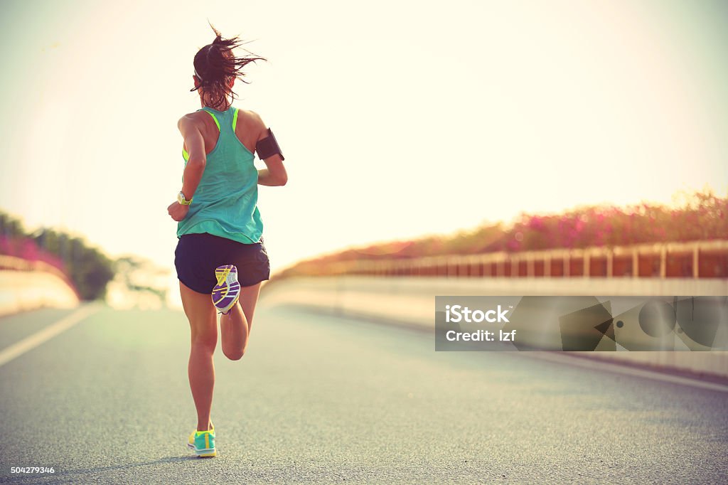 young woman runner running on city bridge road Active Lifestyle Stock Photo