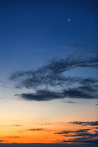 istock Beautiful sunset with fluffy clouds and moon in the sky 504279918