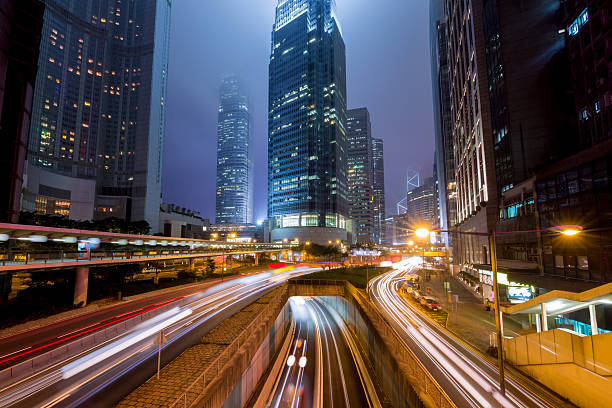 mgła dzielnicy hong kong centrum w nocy z światło track - multiple lane highway zdjęcia i obrazy z banku zdjęć