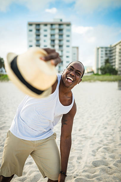 afrikanische mann tanzen am strand von miami - men latin american and hispanic ethnicity young men smiling stock-fotos und bilder