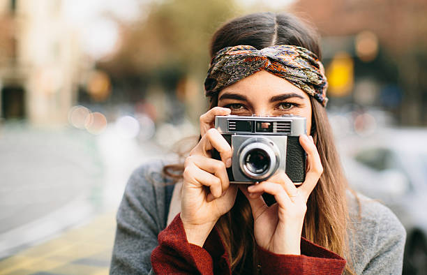 Beautiful woman teasing with a retro camera.