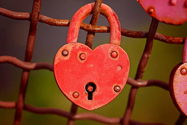 istock Beautiful red heart-shaped padlock locked on iron chain 504283812