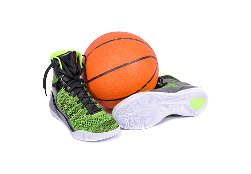 Ultra modern high-top green and black basketball shoes sneakers with a basketball, isolated on white