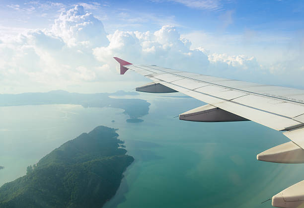istock airplane flying over ocean and island 504287457