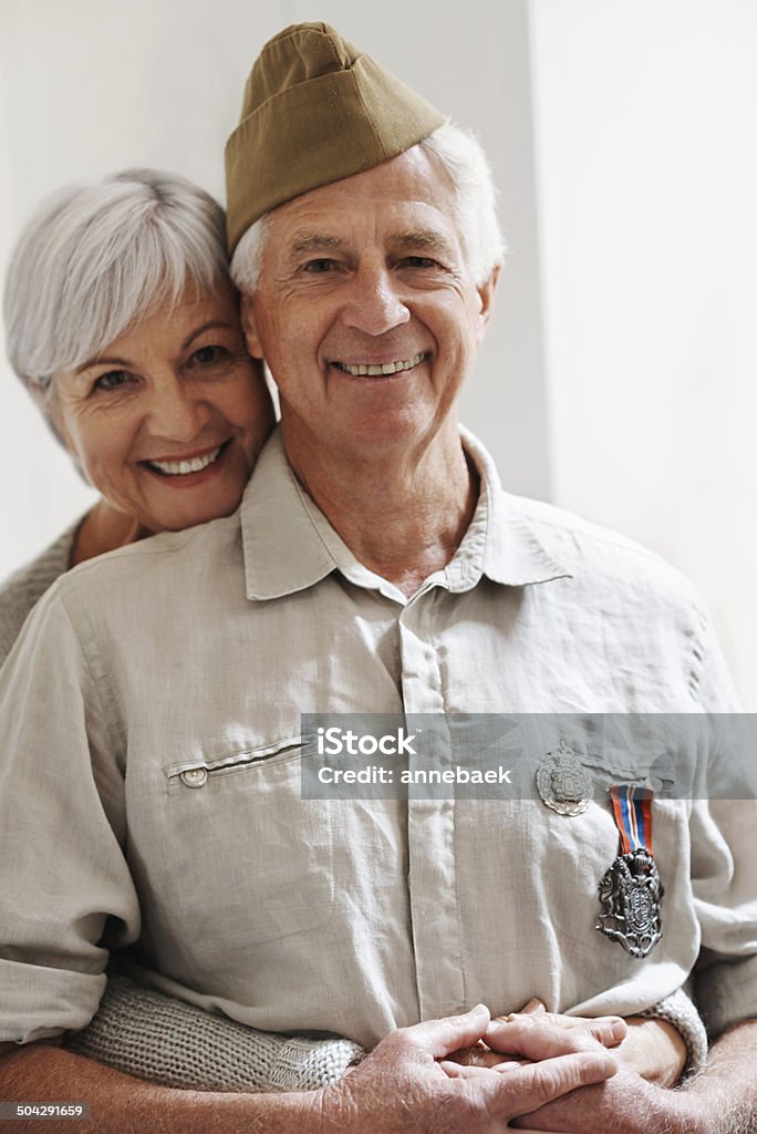 He still looks so handsome in his uniform! Portrait of a wife embracing her husband who is a retired war veteran Veteran Stock Photo