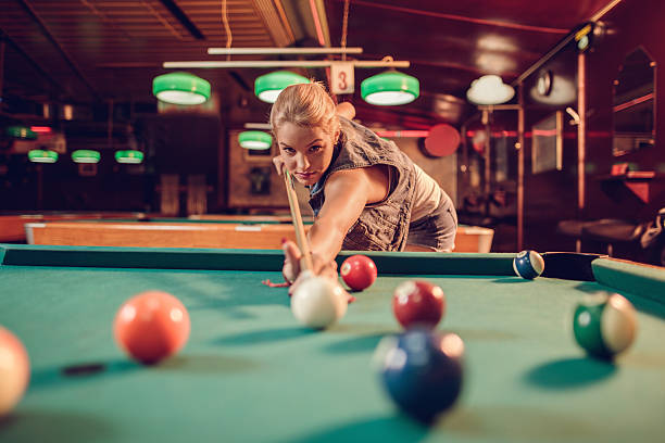 istock Beautiful woman playing pool game in a pub. 504301364