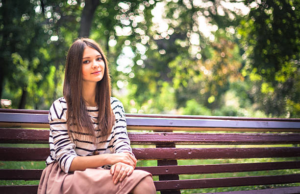 istock Young girl student sitting on yellow bench 504301748