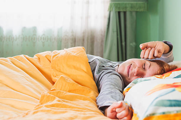 Young woman stretching in bed