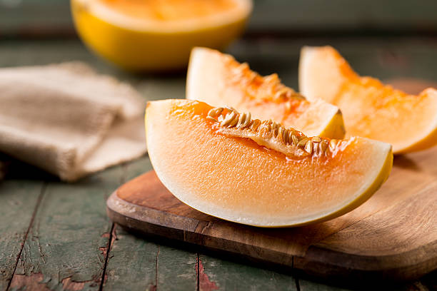 rodajas de melón maduros en una tabla de cortar - cantaloupe fotografías e imágenes de stock