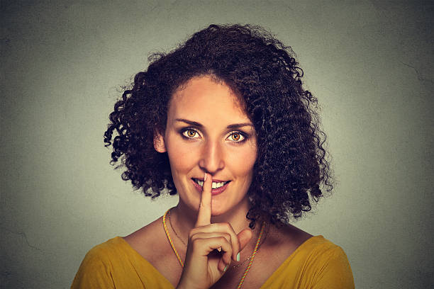 istock hwoman placing finger on lips asking shhh quiet silence 504309214