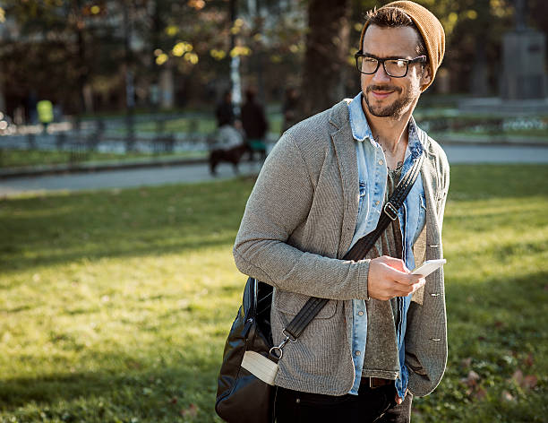 homem elegante bonito usando telefone inteligente - casual smart casual sex symbol sensuality - fotografias e filmes do acervo