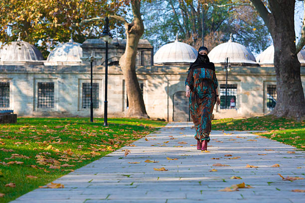 musulmana joven mujer caminando en el parque - nikab veil islam arabia fotografías e imágenes de stock