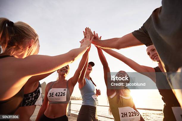 Group Of Athletes High Fiving After Race Stock Photo - Download Image Now - Running, Sport, Winning