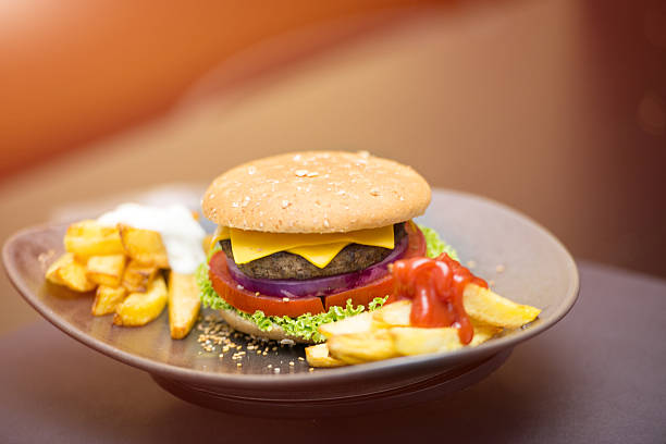 istock Gourmet cheeseburger with potatoes,tomato,onion,on the table 504312706