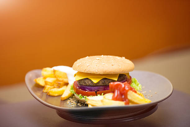 istock Gourmet cheeseburger with potatoes,tomato,onion,on the table 504312824