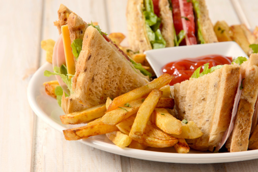 French fries and club sandwiches in the plate on wooden background,selective focus