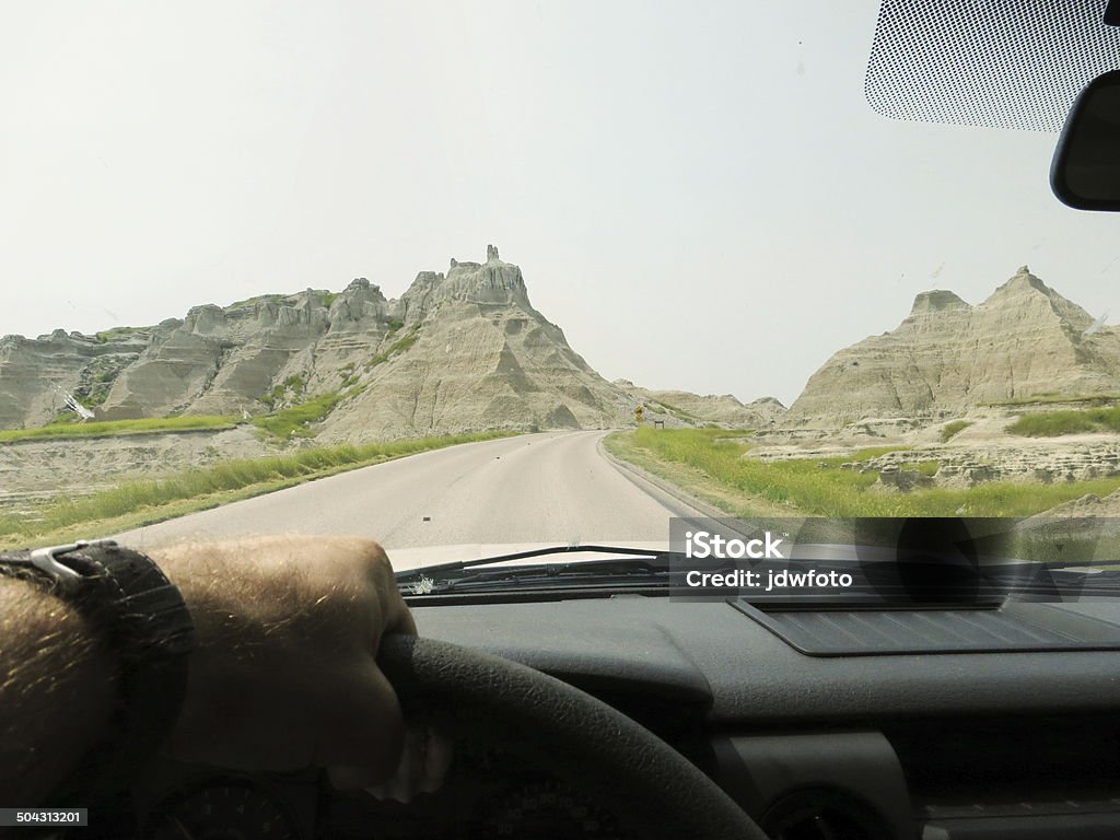 Driving through the Badlands A hand on a steering wheel driving through the desert. Driving Stock Photo