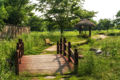 A small park with a bridge and bench in Damyang, South Korea.