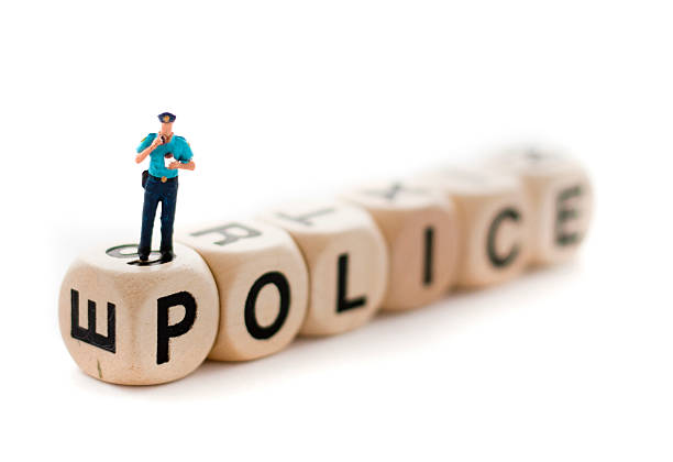 Close-up view of a tiny police officer atop some letter blocks tha spell out \