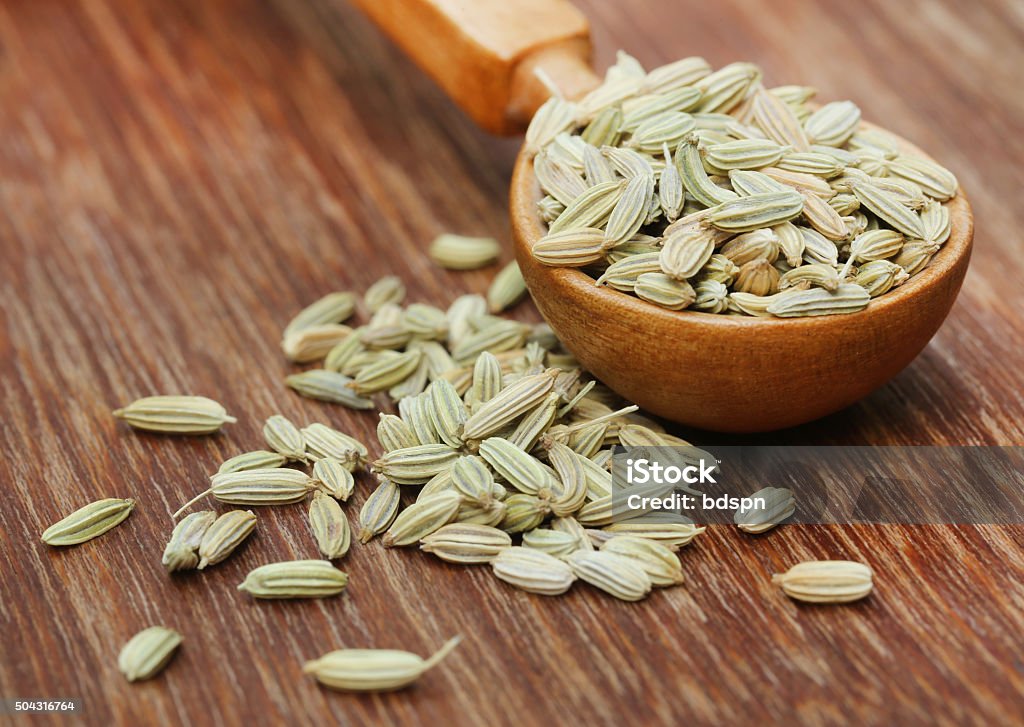 Fennel seeds in a wooden spoon Fennel seeds in a wooden spoon on wooden surface Close-up Stock Photo