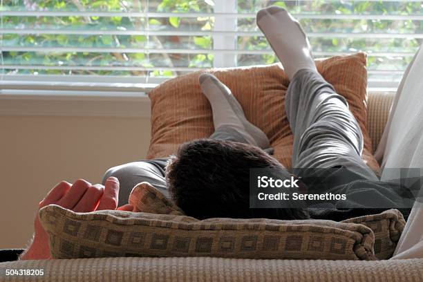 Man Napping On A Couch Stock Photo - Download Image Now - Jogging Pants, Men, Sofa