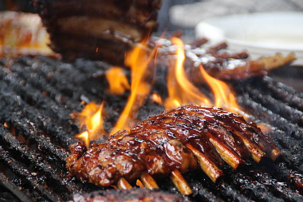 flamme gegrillten rippchen - vom holzkohlengrill stock-fotos und bilder