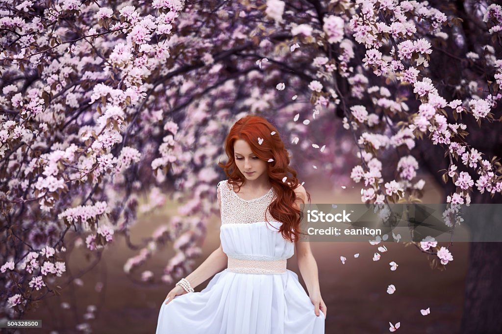 Beautiful young woman under the flowering tree Beautiful young girl under the flowering pink apple-tree Adult Stock Photo