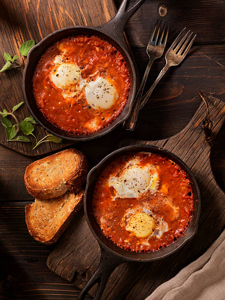 huevos horneada en salsa de tomate picante - sunnyside fotografías e imágenes de stock