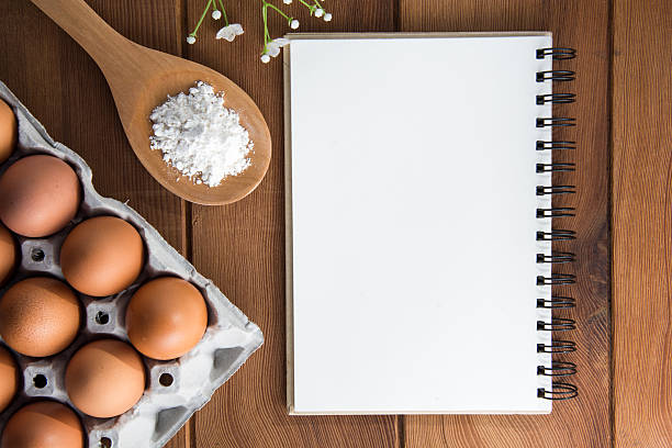 istock Fried eggs with notebook  on the wooden floor. 504329392