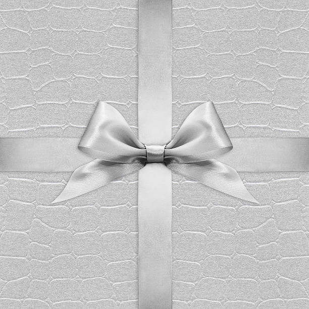 istock Shiny silver satin ribbon bow on argent background 504330234