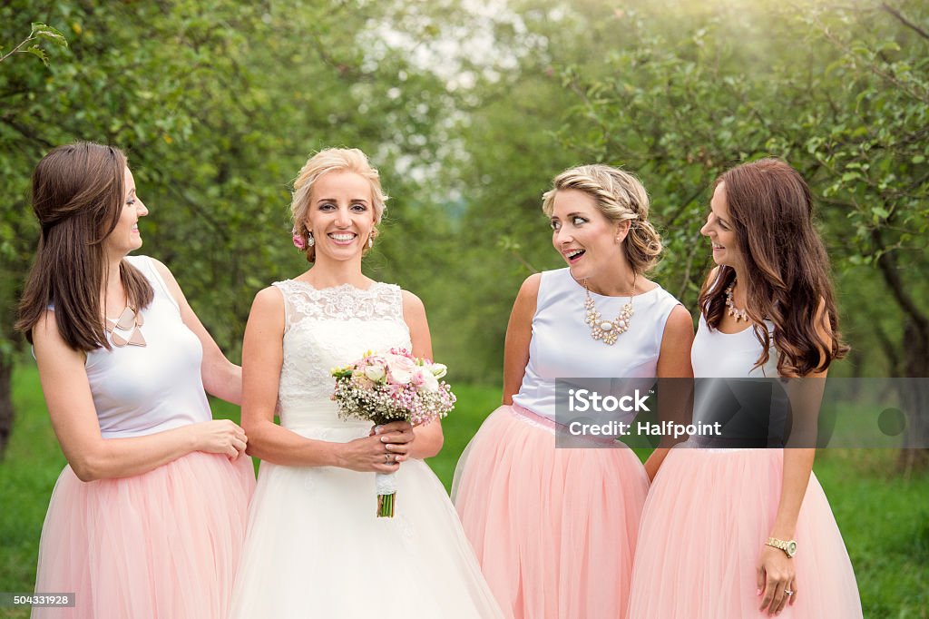 Bride with bridesmaids Beautiful young bride with her bridesmaids outside in nature Adult Stock Photo