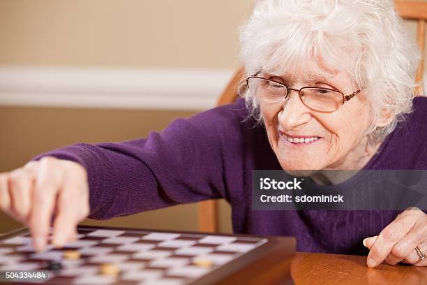 Senior Woman Playing Checkers Stock Photo - Download Image Now - Checkers, Senior Adult, Leisure Games